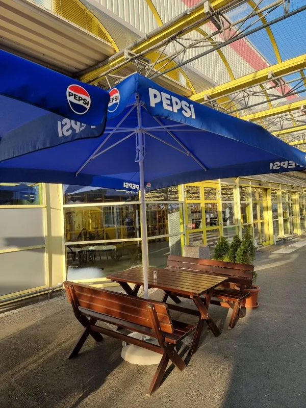 Ogródek ze stolikami pod parasolami oraz parking Baru Jaś w Łodzi